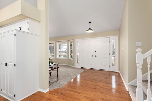 entrance foyer featuring lofted ceiling and light hardwood / wood-style flooring