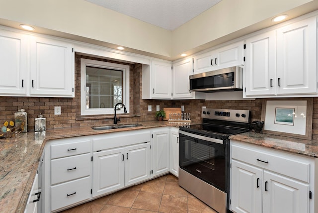 kitchen featuring white cabinetry, appliances with stainless steel finishes, sink, and light stone counters