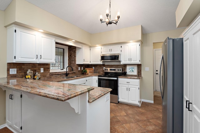 kitchen featuring sink, appliances with stainless steel finishes, white cabinetry, decorative light fixtures, and kitchen peninsula