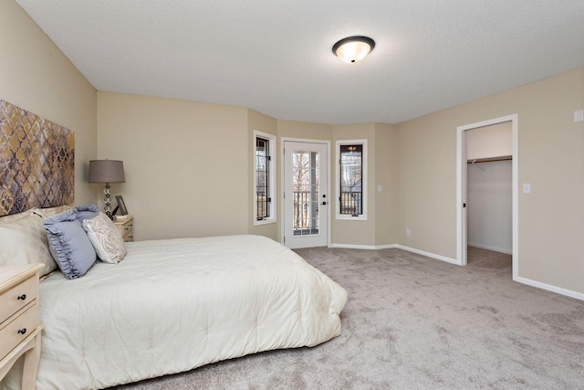 bedroom featuring carpet, a spacious closet, and a textured ceiling