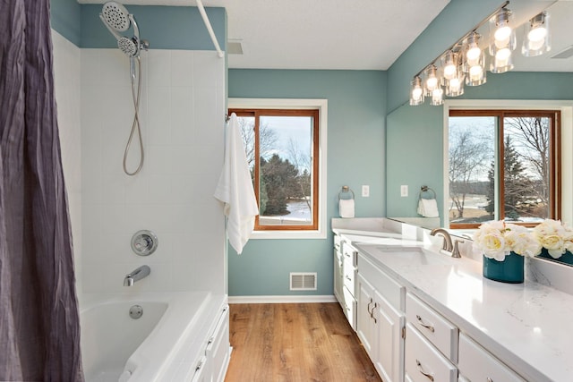 bathroom with tiled shower / bath, wood-type flooring, and vanity