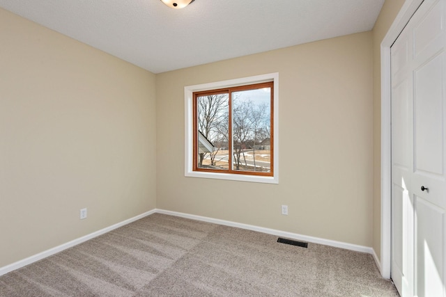 unfurnished bedroom featuring light carpet, a closet, and a textured ceiling