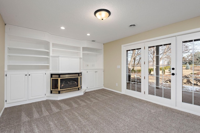 unfurnished living room featuring carpet flooring and a textured ceiling