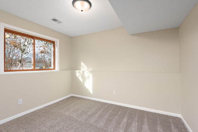 carpeted spare room featuring a textured ceiling