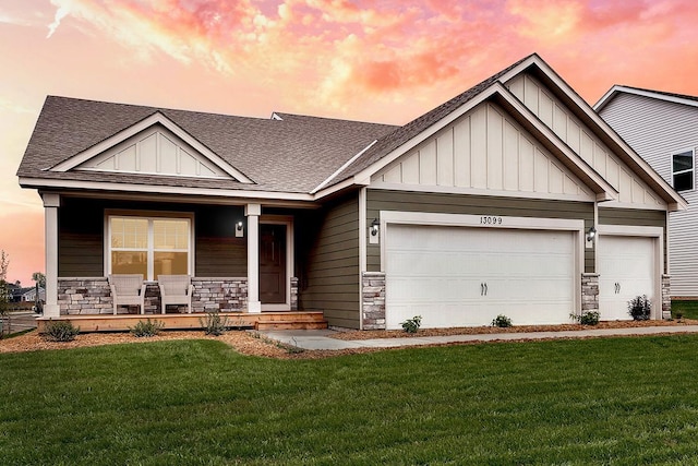 craftsman inspired home with a garage, covered porch, and a lawn