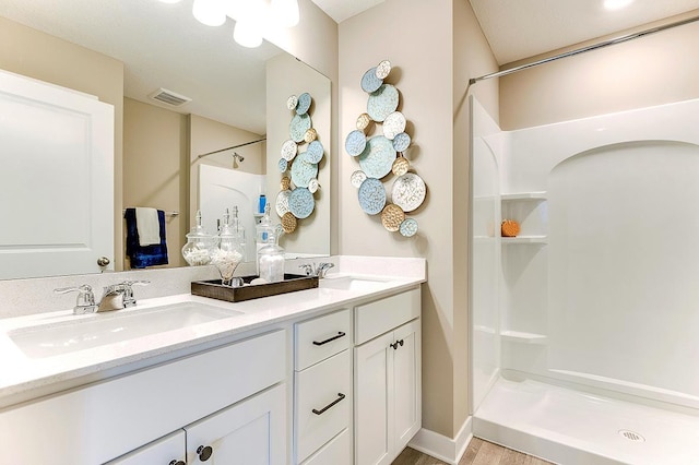 bathroom featuring walk in shower, vanity, and hardwood / wood-style flooring