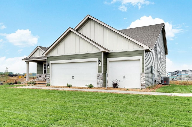 craftsman-style house featuring cooling unit, a garage, covered porch, and a front lawn