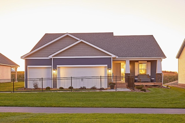 view of front of property with a garage, covered porch, and a front yard