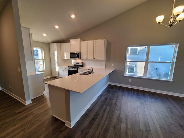 kitchen with white cabinetry, sink, decorative light fixtures, kitchen peninsula, and stainless steel appliances