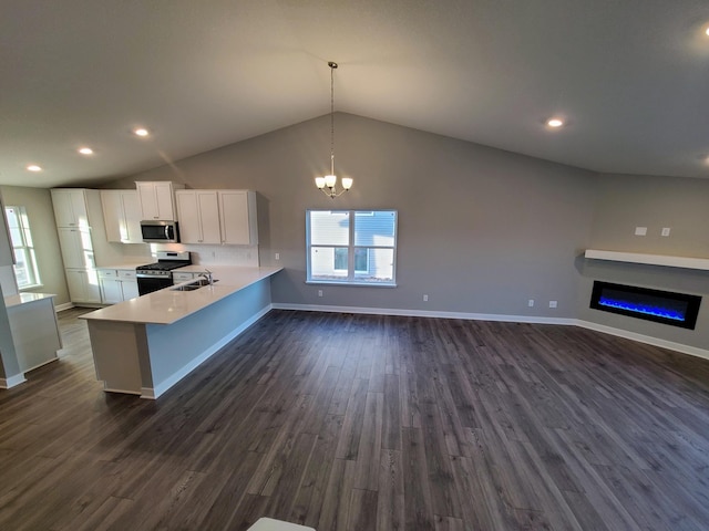 kitchen featuring white cabinets, appliances with stainless steel finishes, hanging light fixtures, dark hardwood / wood-style floors, and kitchen peninsula