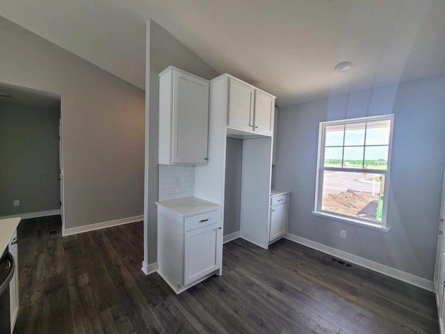 kitchen featuring decorative backsplash, white cabinetry, dark hardwood / wood-style floors, and lofted ceiling