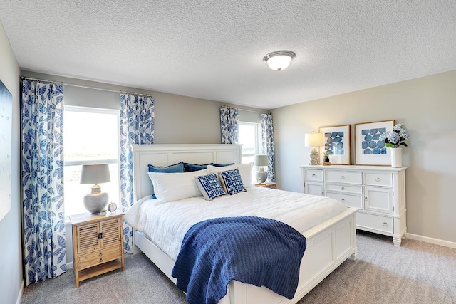 bedroom with light carpet and a textured ceiling