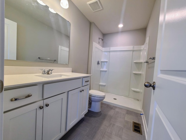 bathroom featuring vanity, toilet, and a shower