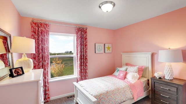 bedroom with multiple windows and dark carpet