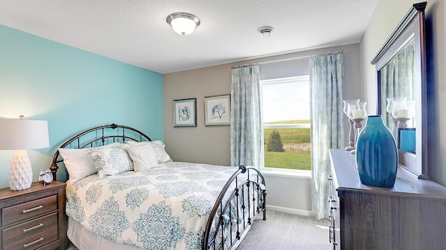 bedroom featuring a textured ceiling and light carpet