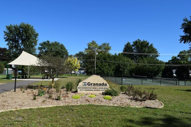 view of tennis court featuring a yard