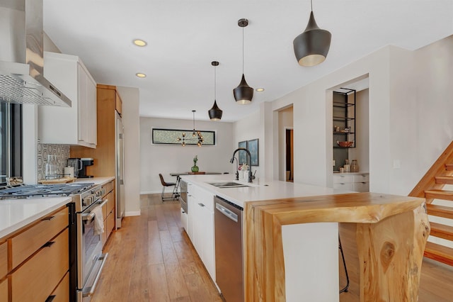 kitchen featuring extractor fan, sink, white cabinetry, a kitchen island with sink, and stainless steel appliances