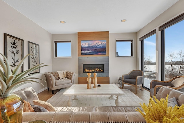 living room with light wood-type flooring and a large fireplace