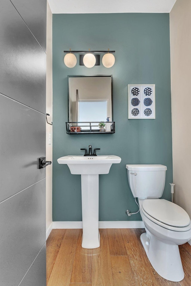 bathroom with toilet and hardwood / wood-style floors