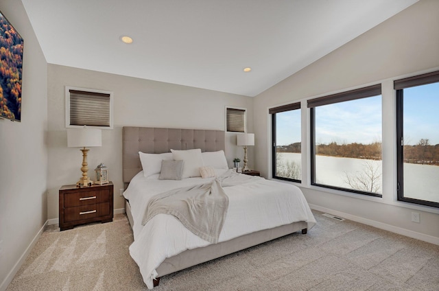 carpeted bedroom with a water view and lofted ceiling