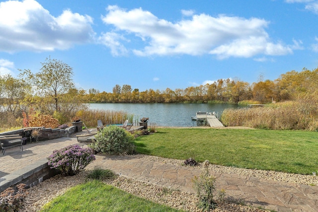 view of dock featuring a patio area, a water view, and a lawn