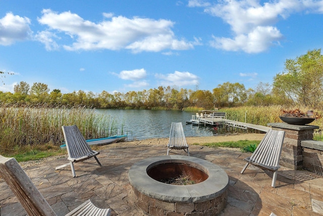 view of patio / terrace featuring an outdoor fire pit, a dock, and a water view