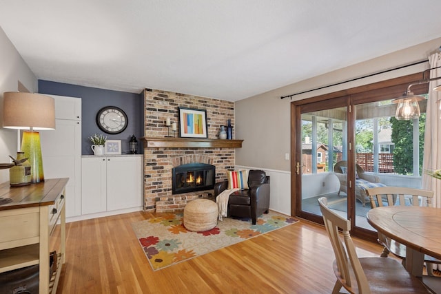2500 Urbandale Ln N, Plymouth, MN 55447 - living room featuring light wood-type flooring, a fireplace, and wainscoting