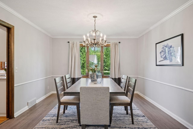 2500 Urbandale Ln N, Plymouth, MN 55447 - dining space featuring a chandelier, wood finished floors, and crown molding