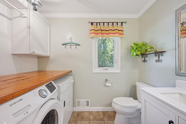 2500 Urbandale Ln N, Plymouth, MN 55447 - bathroom with washer and dryer, vanity, crown molding, and tile patterned flooring