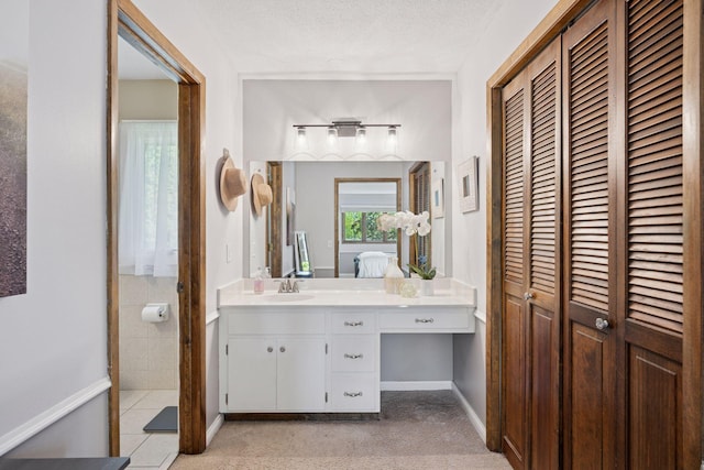 2500 Urbandale Ln N, Plymouth, MN 55447 - ensuite bathroom with a closet, vanity, and a textured ceiling