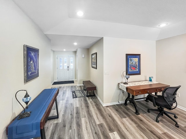 office area with lofted ceiling, wood-type flooring, and a textured ceiling