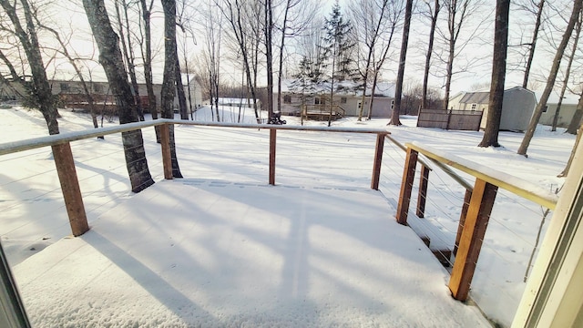 yard layered in snow with a storage shed