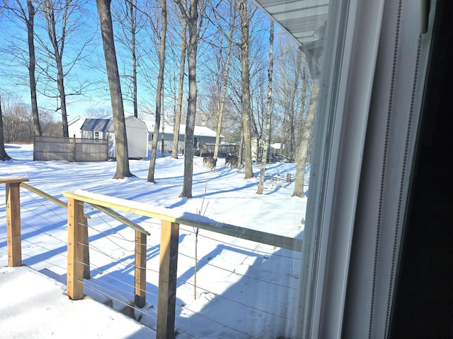 yard layered in snow featuring a shed