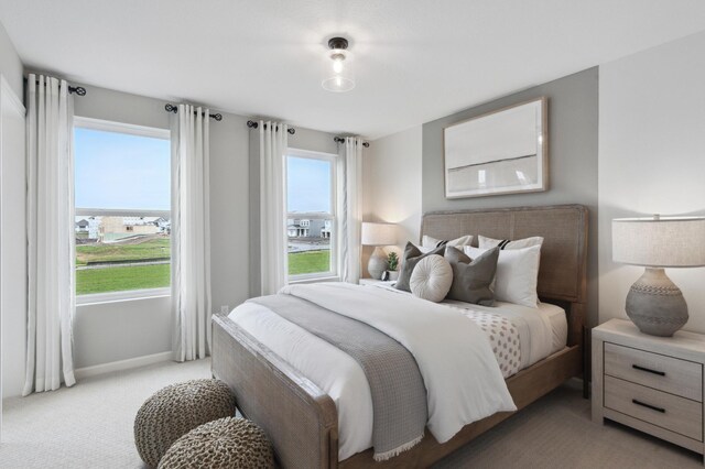 bedroom with light colored carpet and multiple windows