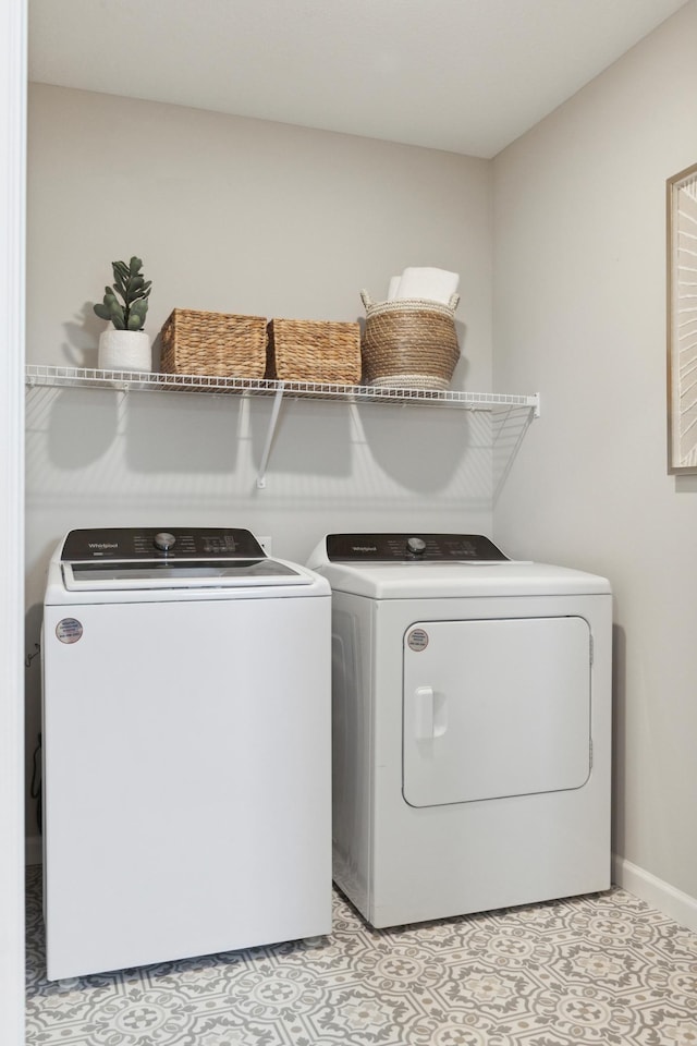 laundry area with light tile patterned floors and washing machine and clothes dryer