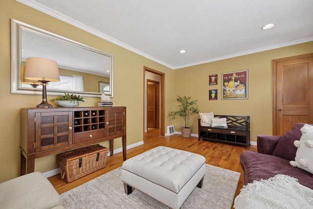 living room featuring visible vents, ornamental molding, wood finished floors, recessed lighting, and baseboards