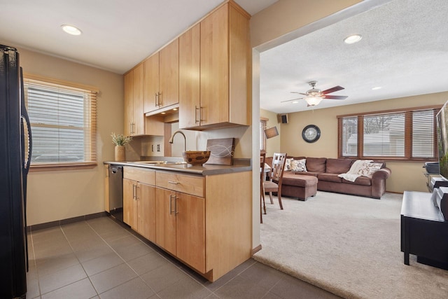 kitchen with a sink, open floor plan, freestanding refrigerator, dark colored carpet, and dishwasher