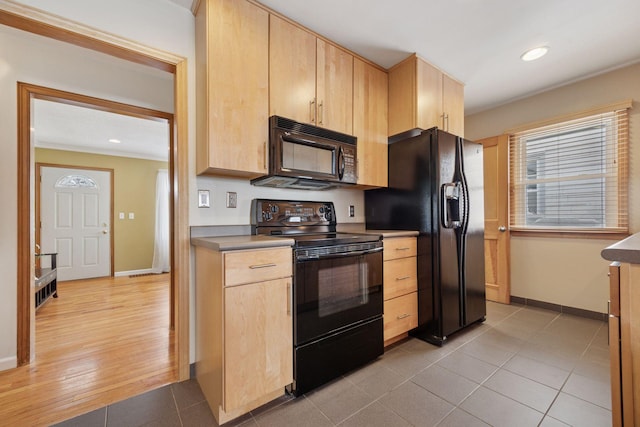 kitchen with light tile patterned floors, baseboards, black appliances, and light brown cabinets