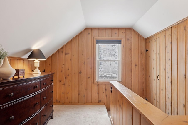 additional living space featuring light carpet, wood walls, and vaulted ceiling