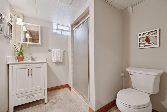 bathroom with baseboards, toilet, vanity, and a shower stall