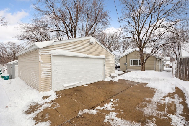 snow covered garage featuring a garage