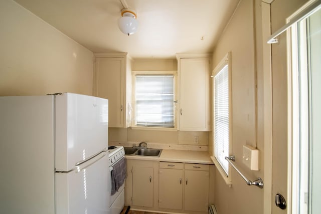 kitchen featuring sink, white appliances, and white cabinets