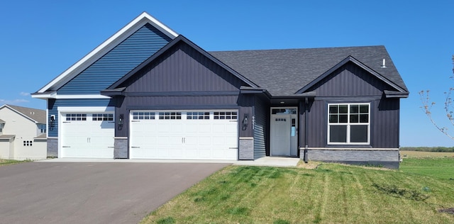 9971 14th Cir NE, Saint Michael, MN 55376 - view of front of home with stone siding, driveway, an attached garage, a front lawn, and roof with shingles