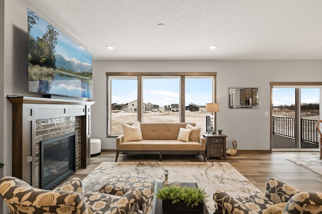 9971 14th Cir NE, Saint Michael, MN 55376 - living room with a tile fireplace, wood finished floors, healthy amount of natural light, recessed lighting, and a textured ceiling