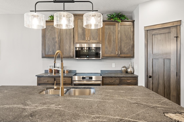 9971 14th Cir NE, Saint Michael, MN 55376 - kitchen with stainless steel appliances, dark countertops, a sink, and pendant lighting