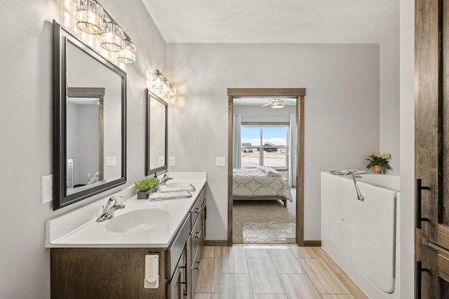 9971 14th Cir NE, Saint Michael, MN 55376 - full bath with double vanity, connected bathroom, baseboards, and a ceiling fan