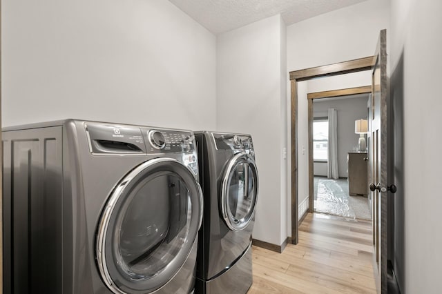 9971 14th Cir NE, Saint Michael, MN 55376 - washroom with independent washer and dryer, light wood-type flooring, a textured ceiling, and baseboards