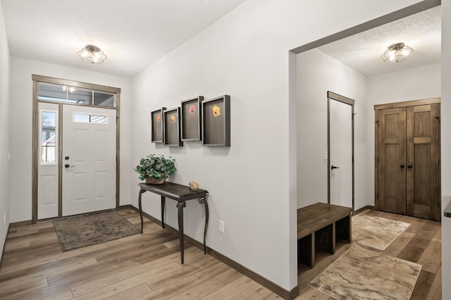 9971 14th Cir NE, Saint Michael, MN 55376 - entryway featuring light wood-style floors, a textured ceiling, and baseboards