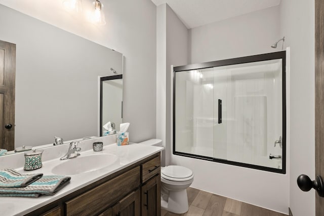 9971 14th Cir NE, Saint Michael, MN 55376 - bathroom featuring vanity, toilet, enclosed tub / shower combo, and wood finished floors