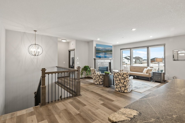 9971 14th Cir NE, Saint Michael, MN 55376 - living area with wood finished floors, a chandelier, recessed lighting, a stone fireplace, and a textured ceiling